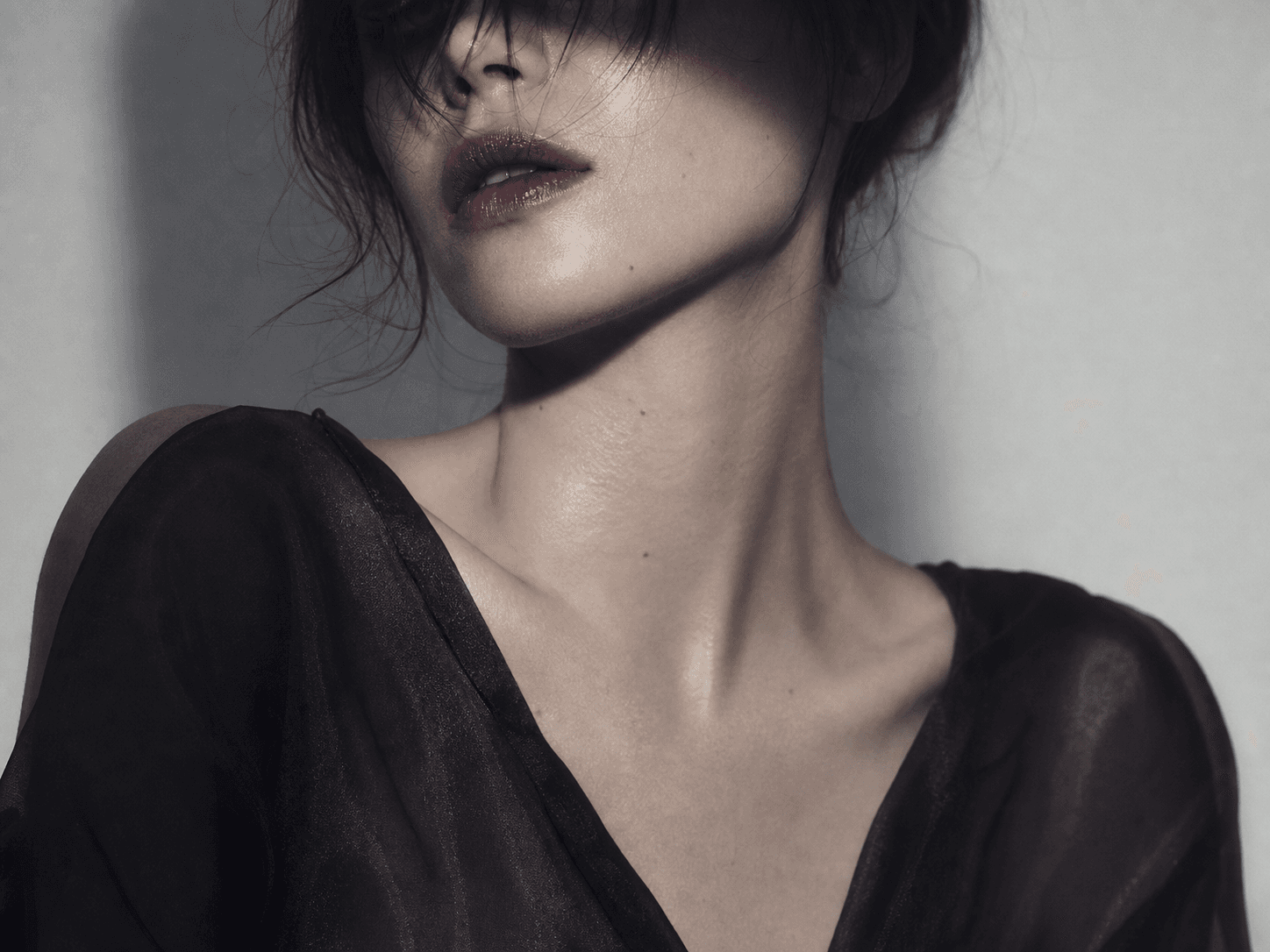 Anonymous high-fashion beauty portrait with smudged eyes and dark satin
